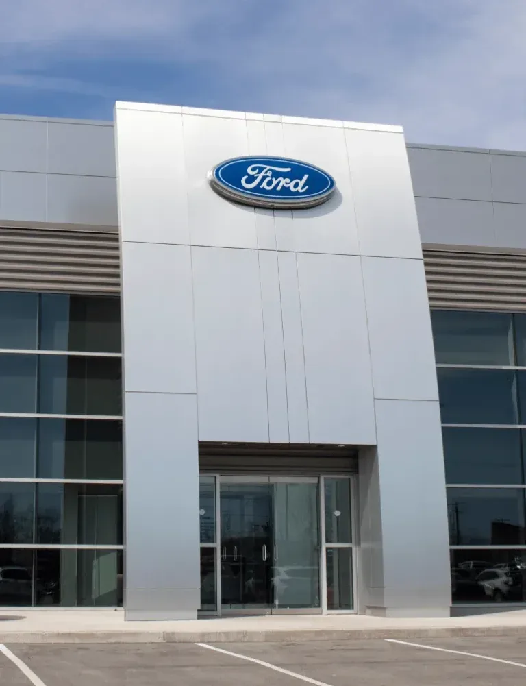 Dealership owners reviewing a sale agreement with an Advantage broker